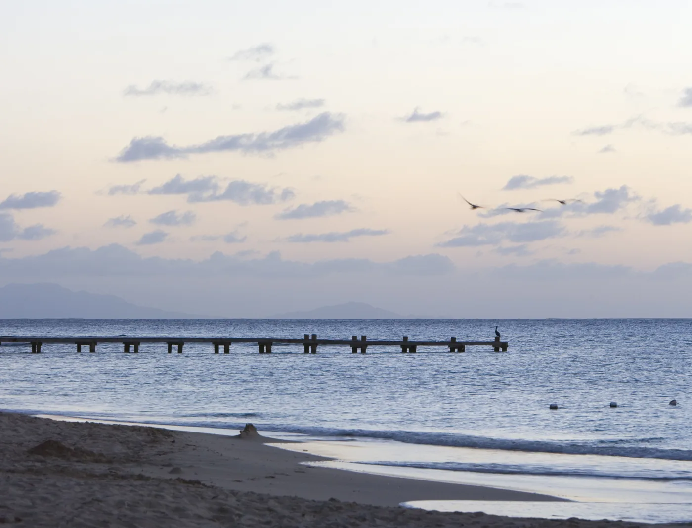 Pale evening sky over the calm sea at Pigeon Point beach near English Harbour, Antigua